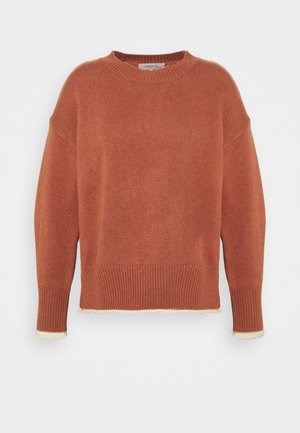 Pull en tricot couleur rouille à col rond, épaules dénudées, poignets et ourlet à côtes, avec une bordure contrastante crème aux bords.