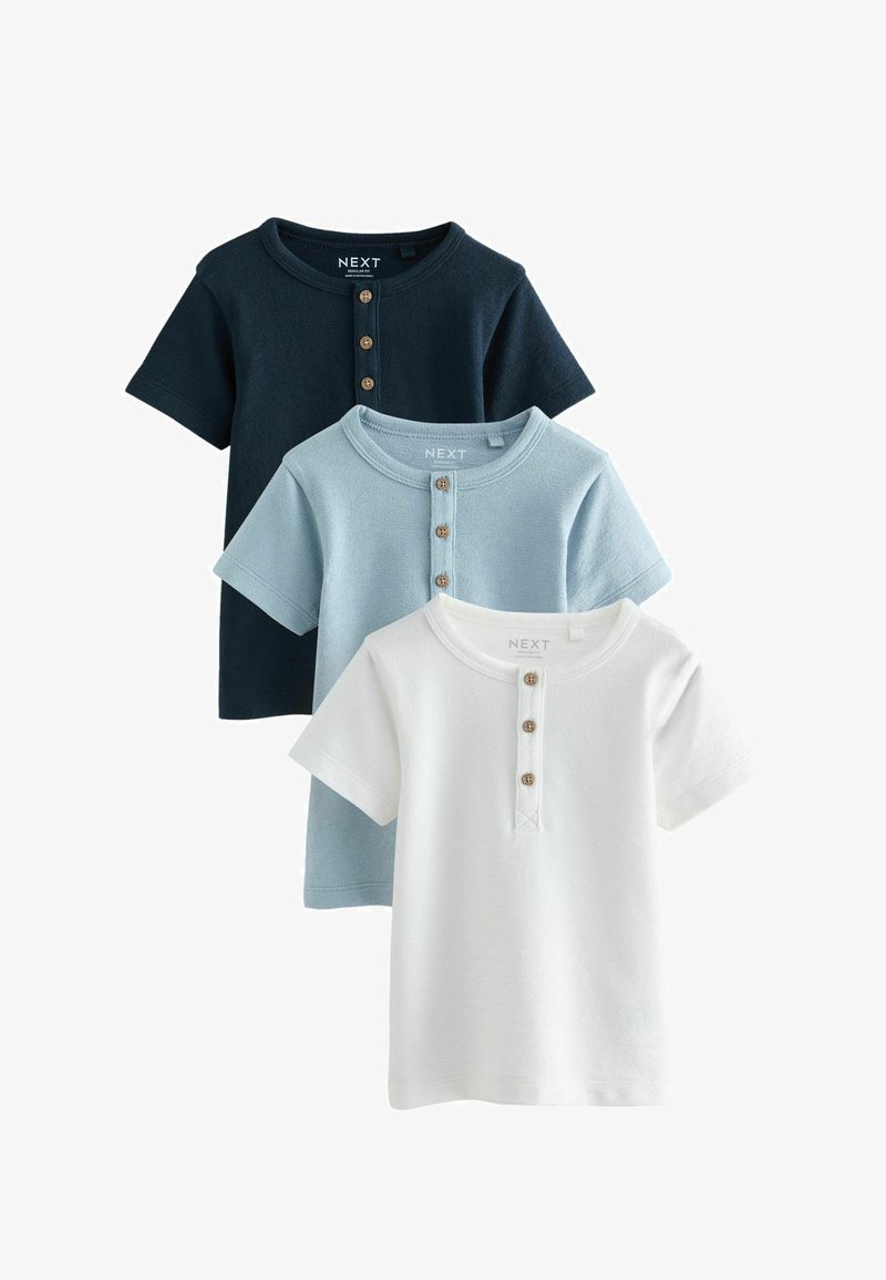 Három rövid ujjú póló tengerészkék, világoskék és fehér színben. Mindegyiken lekerekített nyakvonal és három fa gomb található az elején.