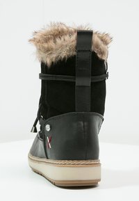 Bota de ante negra con ribete de pelo sintético, puntera redondeada, costuras decorativas y suela de goma. Presenta un diseño elegante y materiales en contraste.