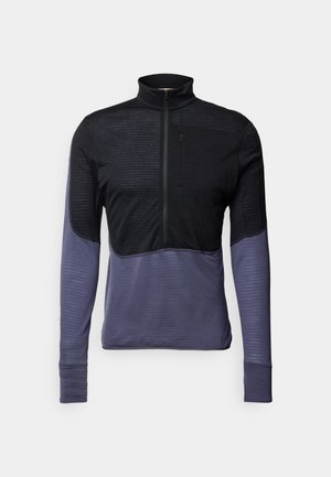 Pull-over à manches longues en noir et violet foncé, avec un col zippé, un haut texturé et des manches inférieures lisses.