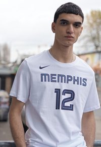 T-shirt Nike blanc avec "MEMPHIS" et le numéro "12" en bleu marine, à manches courtes, col rond, tissu lisse et design athlétique.