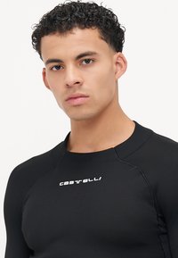 T-shirt de sport noir à manches longues avec texture côtelée, doté d'un col rond et du logo blanc "Castelli" sur la poitrine.