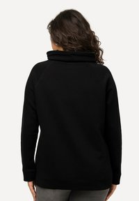 Felpa nera in pile con colletto alto, maniche raglan e vestibilità rilassata. Texture liscia con polsini e orlo a costine.