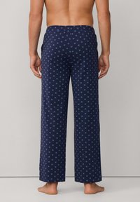 Pantalones de pijama de algodón, de color azul marino con un patrón geométrico en azul claro, diseño de pierna ancha, cintura elástica y bolsillos laterales.