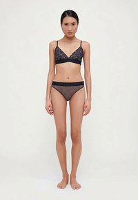 Černá krajková braletka s tenkými ramínky, doplněná o odpovídající černé krajkové bikinové kalhotky. Obě části mají květinový vzor a elastický pas.