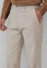 Beige Leinenhose mit texturiertem Finish, geradem Schnitt, seitlichen Taschen und einem knöpfbaren Bund.