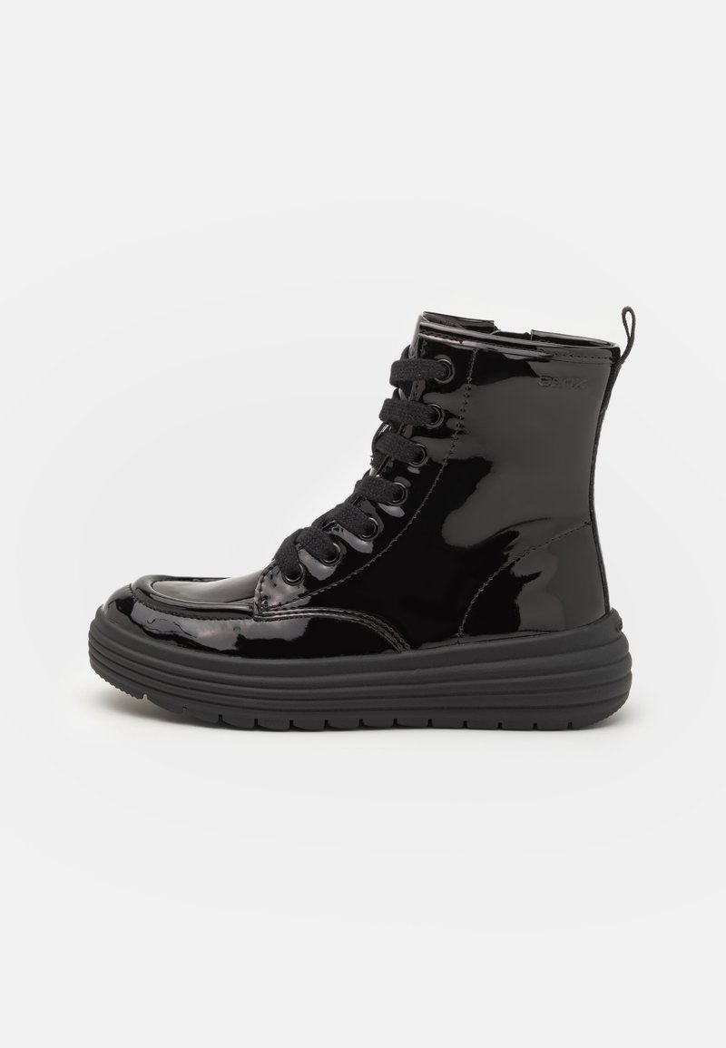 Bottine noire brillante à lacets, semelle épaisse et languette à boucle au talon.