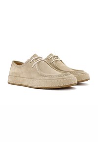 Zapatos de ante beige con punta redondeada, detalles cosidos, cierre de cordones plano y suela de goma texturizada. Diseño de perfil bajo con detalles mínimos.