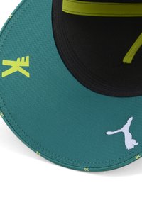 Gorra turquesa con una parte inferior negra, acentos amarillos y un logo blanco. Presenta un visera estructurada y un tejido texturizado.
