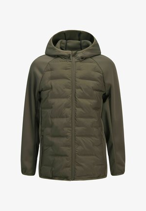 Main insérée dans la poche zippée d'une veste matelassée vert olive avec une manche en tissu doux.