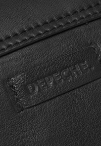 Čierny kožený materiál s textúrovaným povrchom, so šitým okrajom a sembossovanou nášivkou "DEPECHE" na obdĺžnikovej náplasti.