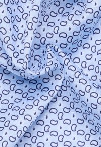 Helles blaues Gewebe mit einem sich wiederholenden dunkeltblauen abstrakten Muster, das geschwungene Formen auf einem strukturierten Hintergrund zeigt. Weiche und glatte Textur.