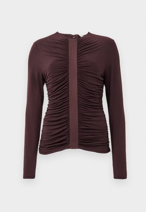 Burgundy long-sleeve top with gathered detailing and a central panel. Smooth fabric, round neckline, and back zipper closure.