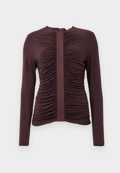 Burgundy long-sleeve top with gathered detailing and a central panel. Smooth fabric, round neckline, and back zipper closure.
