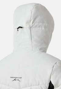 Hvid polstret jakke med en aftagelig hætte, med sorte accenter og "SWEDEMOUNT"-logoet på ryggen, glat tekstur og sømdetaljer.