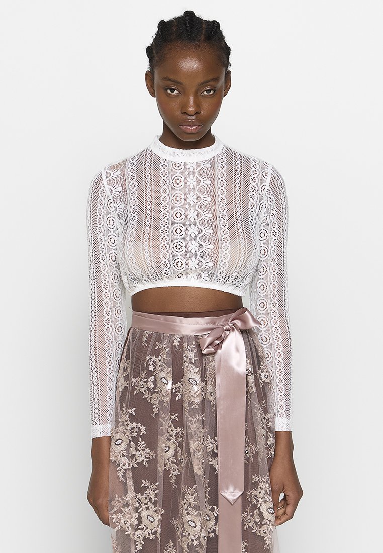 Weiße Spitzen-Crop-Top mit langen Ärmeln, kombiniert mit einem transparenten, hellrosa Rock mit Floralstickerei und einem Satinband zum Binden in der Taille.