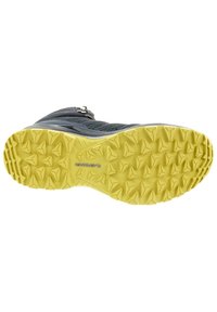 Chaussures avec une semelle extérieure en caoutchouc jaune texturé dotée de crampons triangulaires pour une meilleure adhérence ; la tige est composée d'un mélange de matériaux sombres et de accents gris.