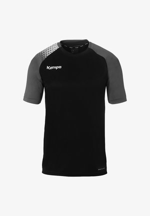 Chemise noire à manches courtes avec des accents gris, présentant un motif géométrique sur l'épaule, fabriquée en tissu évacuant l'humidité. Logo Kempa visible.