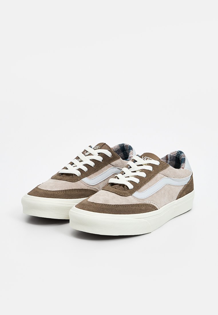 Baskets en suède marron et gris avec des accents en maille blanche et des lacets plats blancs. Semelle en caoutchouc épaisse et doublure intérieure à motifs.