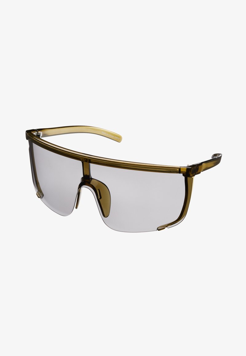 Gafas de sol con un diseño envolvente grande, lentes grises transparentes y montura ligera en color verde oliva. Presentan un puente nasal minimalista.