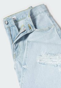 Jeans de mezclilla en azul claro con cierre de cremallera, detalles desgastados y costuras amarillas en la cinturilla y los bolsillos. Textura suave y ajuste regular.