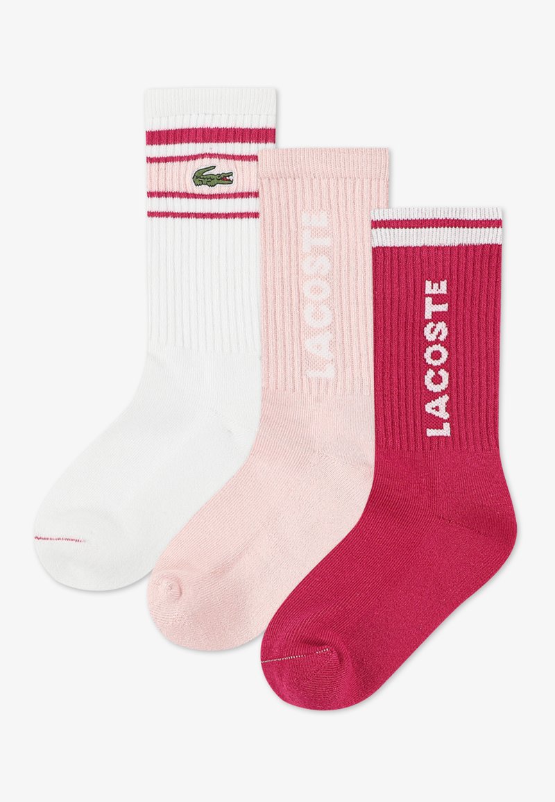 Τρία ζευγάρια κάλτσες: λευκές με κόκκινες ρίγες και λογότυπο, ανοιχτό ροζ ριγέ και σκούρο ροζ με το λογότυπο "LACOSTE", όλα από βαμβακερό μείγμα.