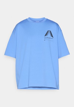 Tricou oversized din bumbac de culoare bleu deschis, cu mâneci scurte, având un imprimeu geometric negru în zona stângă a pieptului și guler rotund.