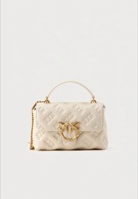 Cream leather handbag with a textured pattern, gold hardware, and a chain strap. Features a prominent gold ring and clasp detail.