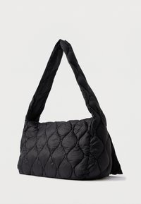 Τσάντα χειρός σε μαύρο χρώμα με καπιτονέ υφή, διαθέτει φαρδύ, στρογγυλό λουρί και σχέδιο ραφής σε σχήμα διαμαντιού.