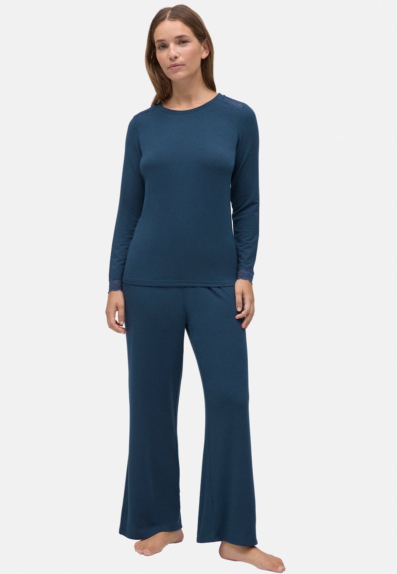 Conjunto de loungewear azul marino hecho de una tela suave; presenta mangas largas, un escote redondo y pantalones acampanados con detalles de encaje.