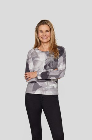 Gray long-sleeve top featuring abstract patterns, textured accents, and a round neck, paired with black pants. Smooth fabric finish.
