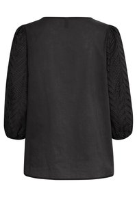 Svart blus med en enfärgad kropp och texturerade, vävda ärmar i trekvartslängd med ett chevronmönster och prickiga detaljer.