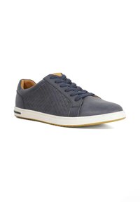 Navy leather sneaker with textured side panel, round toe, white sole, and blue laces. Features a tan interior and subtle stitching detail.