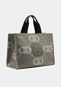 Borsa a spalla grigia in feltro con manici neri, motivo geometrico a catena bianca e toppa frontale con la scritta "LIU JO dal 1995" su sfondo semplice.