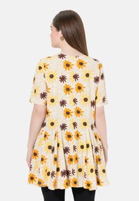 Kleid mit floralem Muster, kurzen Ärmeln, beigem Hintergrund und lebhaften gelben, orangen und braunen Blumen sowie einem plissierten Rockdesign.