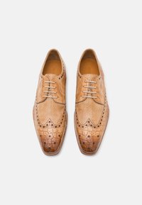 Scarpe da uomo in pelle marrone con punta affusolata, dettagli di forature e texture a coccodrillo sulla parte anteriore. Presentano un design con lacci.