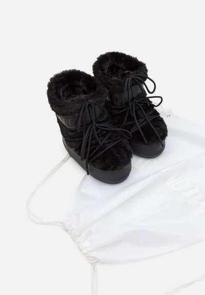 Bocanci din blană neagră cu talpă lucioasă neagră, design cu șnururi și un rucsac cu elastic alb. Prezintă un material superior texturat și accente branduite.