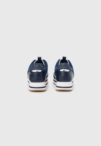 Marineblå joggesko med tekstil- og syntetisk overdel, hvit mellomsåle, gummisåle og mønstrede detaljer på hælen.