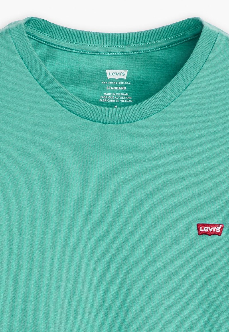 Türkises Baumwoll-T-Shirt mit einem gerippten Rundhalsausschnitt und einem kleinen roten Levi's Logo-Patch auf der linken Brust. Normale Passform, weicher Stoff.