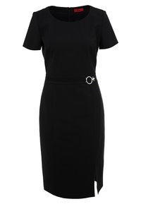 Robe noire longueur genou avec manches courtes, encolure ronde, taille cintrée avec ceinture et boucle circulaire argentée, et fente sur le côté.