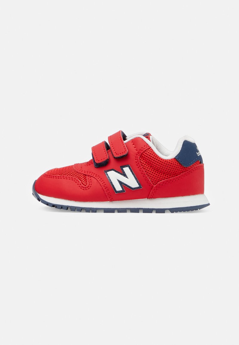 Chaussure de sport rouge avec tige en maille et synthétique, deux bandes Velcro, accents blancs et marine, bout rond et semelle en caoutchouc avec motif texturé.