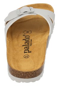 Sandalini bianchi a slip-on con una fodera in sughero, caratterizzati da un dettaglio di fibbia metallica. Soletta morbida e testurizzata e una suola robusta per il supporto.