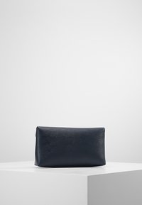 Prostokątna kosmetyczka w granatowym kolorze, wykonana z teksturowanego materiału syntetycznego, z zamkiem błyskawicznym i minimalistycznym designem.