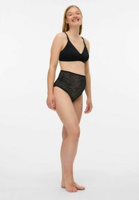 Melnas apakšveļas komplekts ar v-veida izgriezuma braletu ar regulējamām siksniņām un augsta vidukļa biksītēm ar teksturētu viļņotu rakstu.