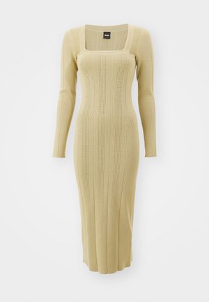 Knit long-sleeve dress in light beige with a square neckline, ribbed texture, and vertical stripes. Form-fitting design with mid-calf length.