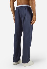 Navy athletic pants with a relaxed fit, made of soft material, featuring an elastic waistband and side seam detailing.