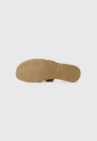 Sandal marrone con una suola liscia e flessibile. Presenta un design piatto e una punta arrotondata, con un piccolo dettaglio della misura impressa sul lato inferiore.
