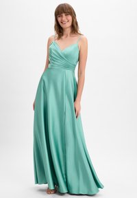 Ein langes, türkisfarbenes Satin-Kleid mit V-Ausschnitt und dünnen Trägern. Es hat geraffte Details am Oberteil und einen fließenden Rock mit einem seitlichen Schlitz.