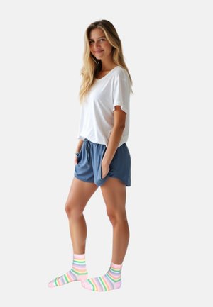 Hvid kortærmet t-shirt, blå shorts med snoretræk og lommer, samt knæhøje sokker med regnbue-striber i pink, grøn og gul.