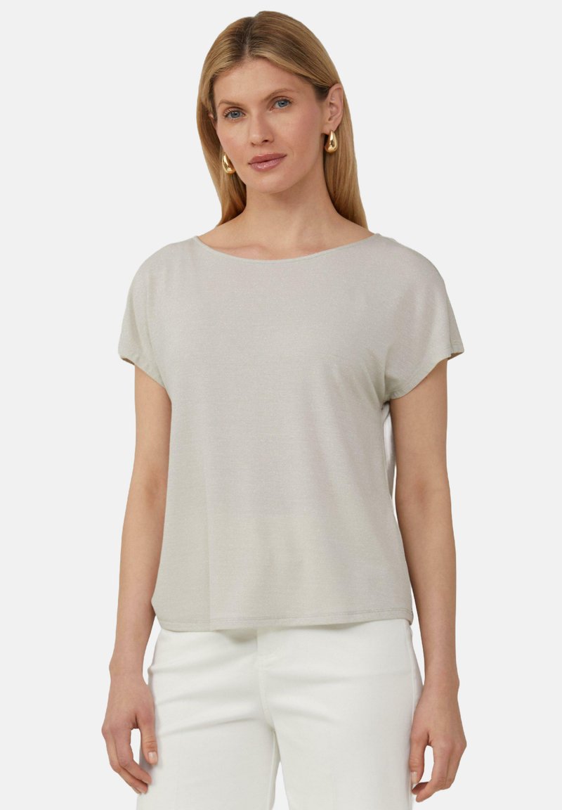 Jasnoszary t-shirt z krótkim rękawem, okrągłym dekoltem, miękką fakturą i luźnym krojem; zestawiony z białymi spodniami, prezentując casualowy outfit.